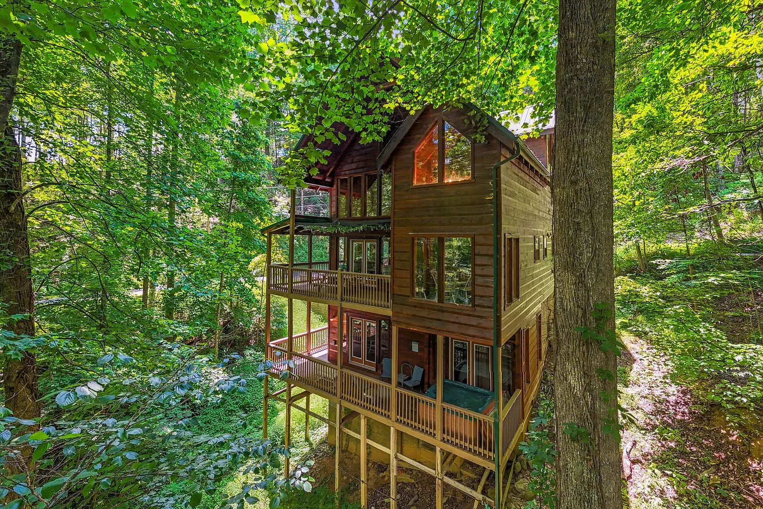 Smoky Summit Stays cabin exterior surrounded by green wooded scenery in Sevierville, Tennessee