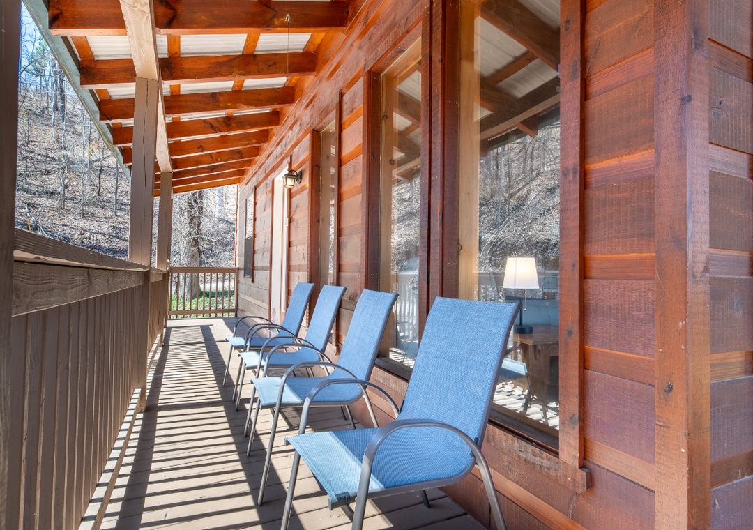 Wraparound deck with blue chairs at Smoky Summit Stays